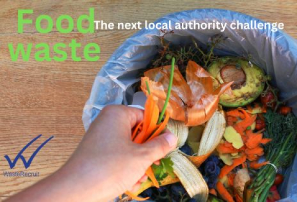 A hand placing food waste into a lined small bin/bucket containing vegetable peelings