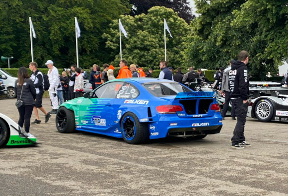 blue modern racing car parked on an outside track area