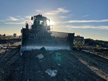 Earth moving vehicle positioned on a landfill