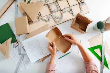 cardboard box packaging prototype with designs on paper
