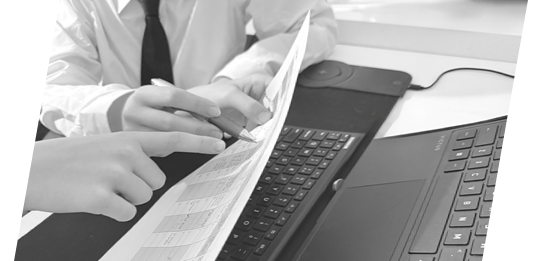 hands pointing to spreadsheet by a keyboard